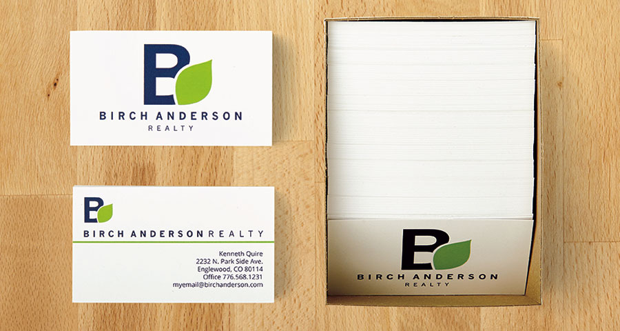 Box of double-sided business cards, with one sample displayed on a desk